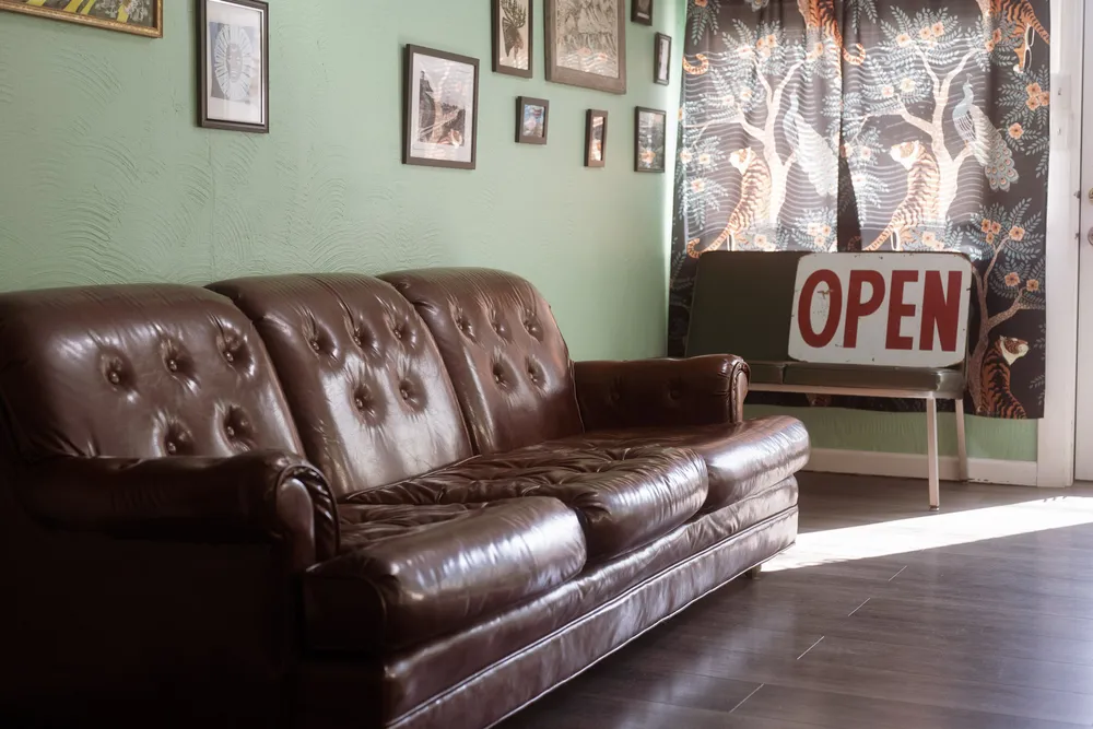 Couch in barbershop with open sign visible